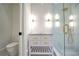 Bathroom featuring white vanity, gold hardware, glass shower and tiled walls at 4550 Jolyn Pl, Sandy Springs, GA 30342