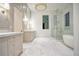 Bright bathroom featuring a glass shower, tub, double sink vanity, and marble floors at 4550 Jolyn Pl, Sandy Springs, GA 30342