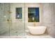 Luxurious bathroom featuring marble tile, glass shower, freestanding tub and gold fixtures at 4550 Jolyn Pl, Sandy Springs, GA 30342