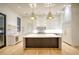 Modern eat-in kitchen with white cabinets, hardwood floors and center island with marble countertops at 4550 Jolyn Pl, Sandy Springs, GA 30342