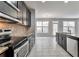 Well-lit kitchen featuring dark wood cabinets, granite countertops, stainless steel appliances, and tile flooring at 137 Staley Dr, Tucker, GA 30084