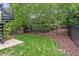 View of a lush backyard with privacy fence and black metal spiral staircase at 210 Marjean Way, Alpharetta, GA 30009