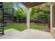 View of a backyard with privacy fence, green grass, and a black metal spiral staircase leading to the above floors at 210 Marjean Way, Alpharetta, GA 30009