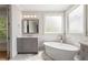Bright bathroom with a freestanding tub, and a window at 210 Marjean Way, Alpharetta, GA 30009