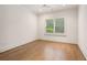 Bright bedroom featuring hardwood floors and trim, large window with blinds, ceiling fan, and modern lighting at 210 Marjean Way, Alpharetta, GA 30009