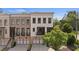 Charming townhome showcasing a brick facade, a covered front porch, and a two-car garage at 210 Marjean Way, Alpharetta, GA 30009