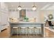 Modern kitchen featuring a large island with stool seating, pendant lighting, and stainless appliances at 210 Marjean Way, Alpharetta, GA 30009
