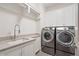 Modern laundry room featuring a sink, counter space, cabinets, and washer and dryer at 210 Marjean Way, Alpharetta, GA 30009