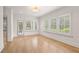 Bright living room with beautiful hard wood floors, white trim, modern recessed lighting, and three windows at 210 Marjean Way, Alpharetta, GA 30009