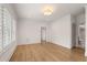 Bright room with wood floors, white trim, and a modern light fixture, with an open door to an en-suite bath at 210 Marjean Way, Alpharetta, GA 30009