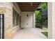 View of the patio area with a tan brick facade and a black metal spiral staircase on the side of the home at 210 Marjean Way, Alpharetta, GA 30009