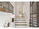 Elegant staircase featuring hardwood steps, white risers, and a decorative black iron railing at 210 Marjean Way, Alpharetta, GA 30009