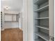 A view into a walk-in closet with custom shelving and wood floors at 210 Marjean Way, Alpharetta, GA 30009