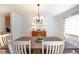 Elegant dining room with a modern chandelier, a wooden table, and views of the lush greenery outside at 503 Hearthstone Rdg, Woodstock, GA 30189