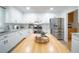 Modern kitchen with white cabinets, granite countertops, a wooden island, and stainless steel appliances at 503 Hearthstone Rdg, Woodstock, GA 30189