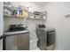 Laundry room features modern washer and dryer, with storage shelves at 503 Hearthstone Rdg, Woodstock, GA 30189
