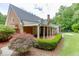 Home exterior with a covered patio, well-manicured hedges, and a beautiful maple tree in the landscape at 7660 Dunvegan Close, Sandy Springs, GA 30350