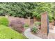Landscaped backyard with lush bushes, brick garden gate, and stone pathway leading to the residence at 7660 Dunvegan Close, Sandy Springs, GA 30350