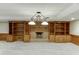 Basement fireplace with brick surround, built-in shelving, and a decorative light fixture at 7660 Dunvegan Close, Sandy Springs, GA 30350