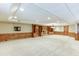 Spacious carpeted basement with wood paneled walls, built-in shelving, and recessed lighting at 7660 Dunvegan Close, Sandy Springs, GA 30350