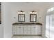 Bathroom featuring double vanity, granite countertop, decorative mirrors, and ample cabinet space at 7660 Dunvegan Close, Sandy Springs, GA 30350