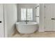 Bright bathroom featuring a modern standalone tub with black hardware and a window at 7660 Dunvegan Close, Sandy Springs, GA 30350