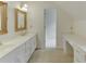 Bathroom featuring a double sink vanity, countertop, ornate mirrors, and drawer space at 7660 Dunvegan Close, Sandy Springs, GA 30350