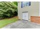 Side entry garage with lush greenery and manicured lawn, located close to the side of the home at 7660 Dunvegan Close, Sandy Springs, GA 30350