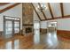 Spacious living room with wood floors, beamed ceiling, stone fireplace, and custom wainscoting at 7660 Dunvegan Close, Sandy Springs, GA 30350