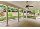 Covered patio with brick flooring, white columns, ceiling fan, and manicured landscaping creating a serene outdoor space at 7660 Dunvegan Close, Sandy Springs, GA 30350