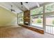 Light-filled sunroom with brick flooring, stone fireplace, vaulted ceilings, and large windows overlooking the backyard at 7660 Dunvegan Close, Sandy Springs, GA 30350