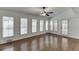 Light-filled sunroom with hardwood floors, ceiling fan, and multiple windows with plantation shutters at 7660 Dunvegan Close, Sandy Springs, GA 30350