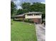 Split-level home with brick and siding, green lawn and mature trees at 2433 Tilson Rd, Decatur, GA 30032