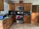 Cozy kitchen with wood cabinets, stainless steel appliances, and tiled floors at 2433 Tilson Rd, Decatur, GA 30032
