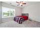 Bright bedroom with a large window, neutral walls, carpeted floors, and a bed with modern patterned bedding at 2646 Neighborhood S Walk, Villa Rica, GA 30180