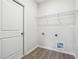 Simple laundry room with wood floors, shelving, and hookups for washer and dryer at 2646 Neighborhood S Walk, Villa Rica, GA 30180