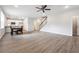 Open-concept living room with wood floors, staircase, and adjacent kitchen with granite countertops at 2646 Neighborhood S Walk, Villa Rica, GA 30180