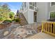 Back of home featuring stone patio, wooden deck, steps, mature landscaping and side door entrance at 3330 Arborwoods Dr, Alpharetta, GA 30022