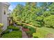 Beautifully landscaped backyard, featuring lush green lawn, mature trees, and garden beds at 3330 Arborwoods Dr, Alpharetta, GA 30022