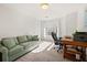 Home office featuring an arched window, cozy green couch and wood desk at 3330 Arborwoods Dr, Alpharetta, GA 30022