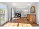 Bright living room featuring hardwood floors, a piano, and natural lighting at 3330 Arborwoods Dr, Alpharetta, GA 30022