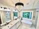 A bright bathroom featuring a chandelier, a standalone tub, and marble countertops at 3820 Fox Creek Ct, Marietta, GA 30062