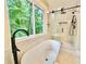 This bathroom has a freestanding tub next to large window and frameless glass shower at 3820 Fox Creek Ct, Marietta, GA 30062