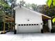 This home boasts a white two-car garage with a concrete driveway and stairs to a wooden deck above at 3820 Fox Creek Ct, Marietta, GA 30062