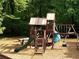 A large wooden playground with a slide, ladders, and swings set amidst a wooded area at 3820 Fox Creek Ct, Marietta, GA 30062