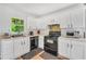 Well-lit kitchen featuring white cabinets, black appliances, and modern fixtures at 4682 Stonewall Tell Rd, College Park, GA 30349