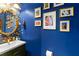 Stylish powder room with blue walls, decorative wallpaper, and gold accents at 5655 Hedge Brook Dr, Cumming, GA 30028