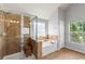 Bathroom features a tiled shower, soaking tub, and natural light at 5655 Hedge Brook Dr, Cumming, GA 30028