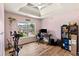 Bright bedroom with tray ceilings, a large window, and versatile setup for work and exercise at 5655 Hedge Brook Dr, Cumming, GA 30028