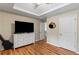 Bedroom with tray ceilings, wood floors, and a dresser at 5655 Hedge Brook Dr, Cumming, GA 30028